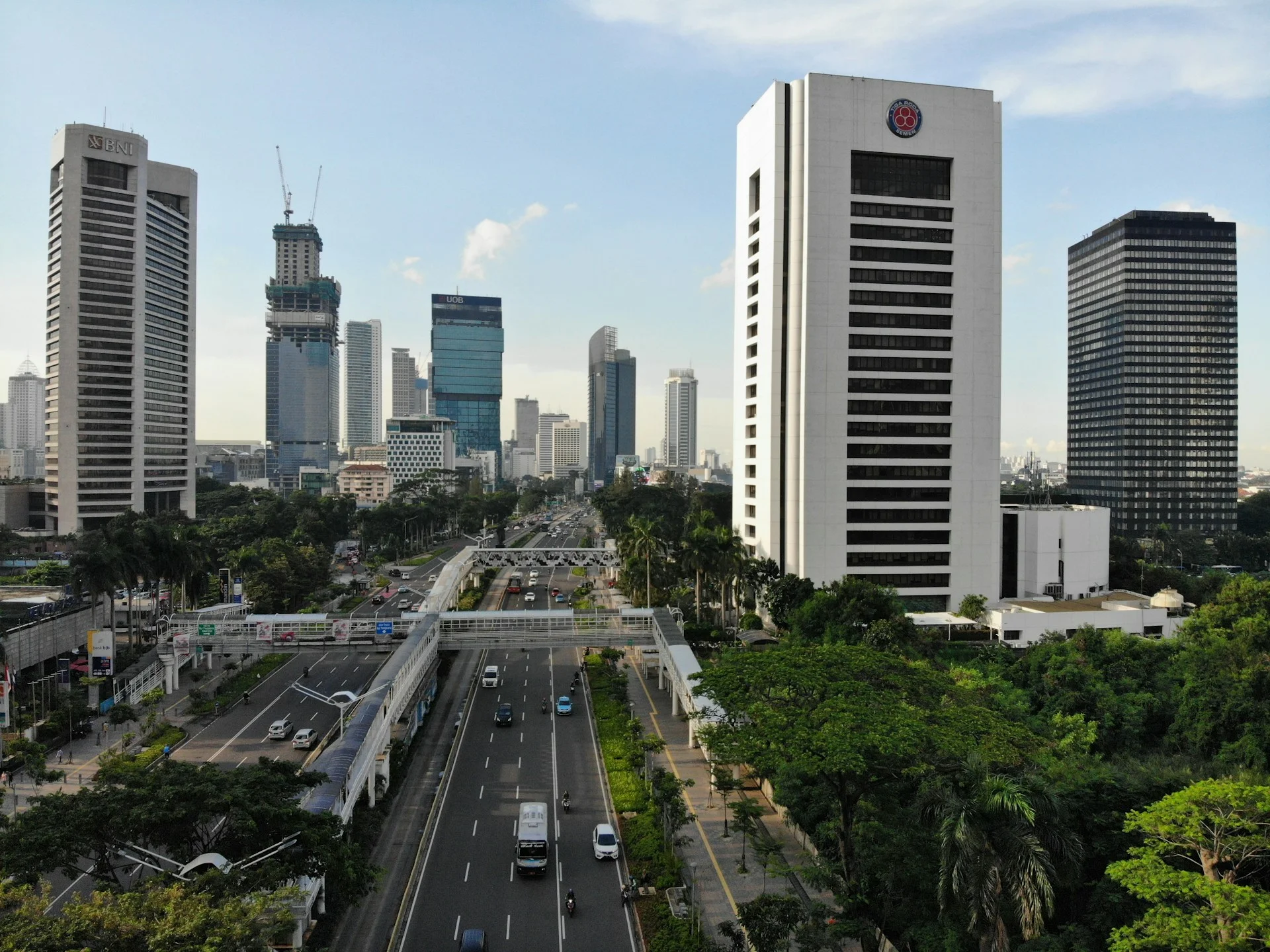 Kendaraan bergerak di jalan kawasan perkotaan dengan deretan bangunan