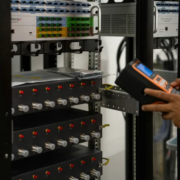 Teknisi memeriksa rak server dengan alat diagnostik