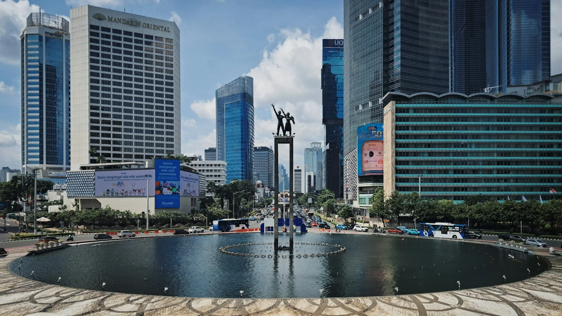 Lanskap kota dengan bangunan modern mengelilingi sebuah monumen