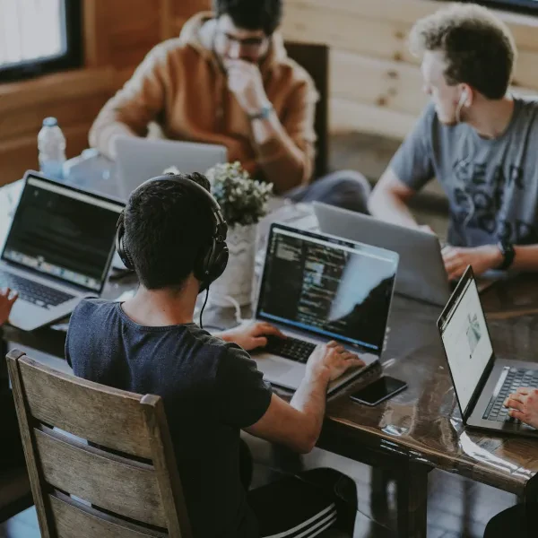 Sekelompok orang berdiskusi sambil menggunakan laptop