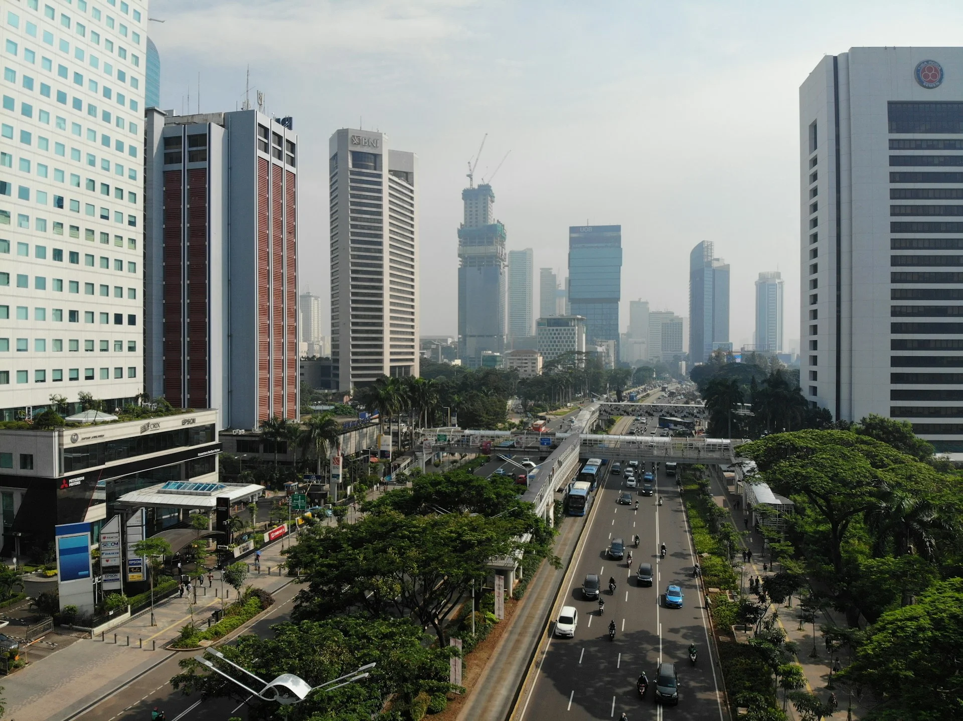 Kendaraan melintas di antara gedung tinggi kawasan perkotaan