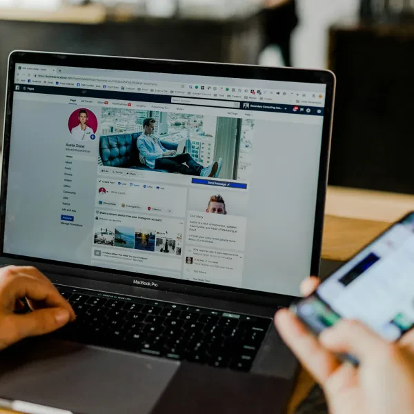 Seseorang menggunakan laptop dan ponsel secara bersamaan