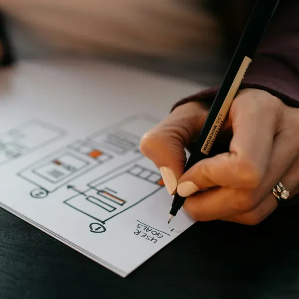 Seseorang menulis rencana pada kertas putih