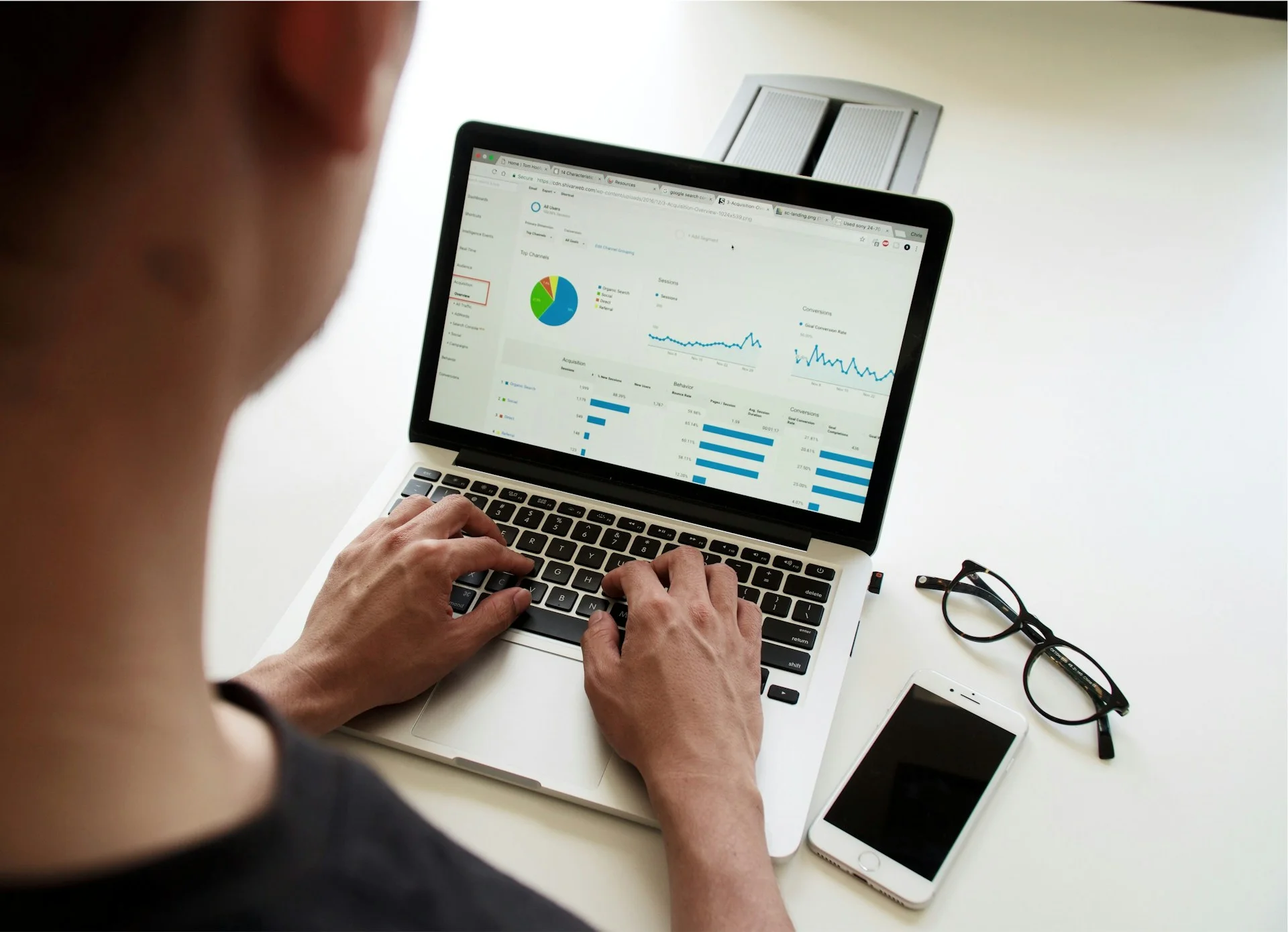 Seseorang memeriksa grafik dan laporan pada layar laptop