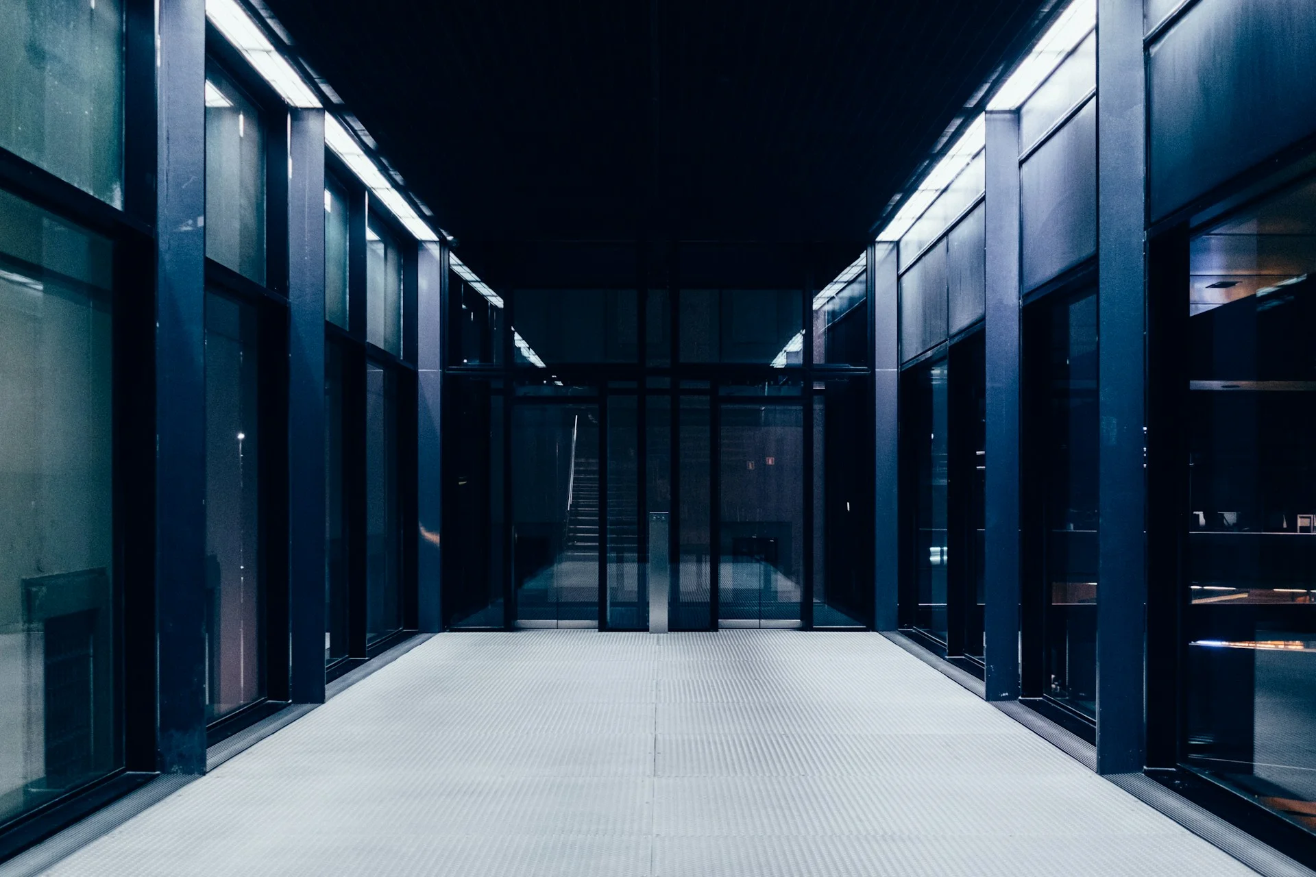 Lorong pusat data dengan deretan rak server dan pencahayaan biru